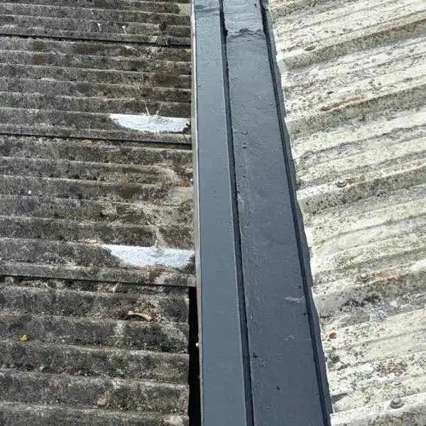 Lava 20 waterproofing coating applied to asbestos roof valley sections showing seamless membrane formation bridging cracks and joints